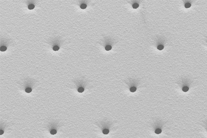 Microholes with trumpet profile (REM image)